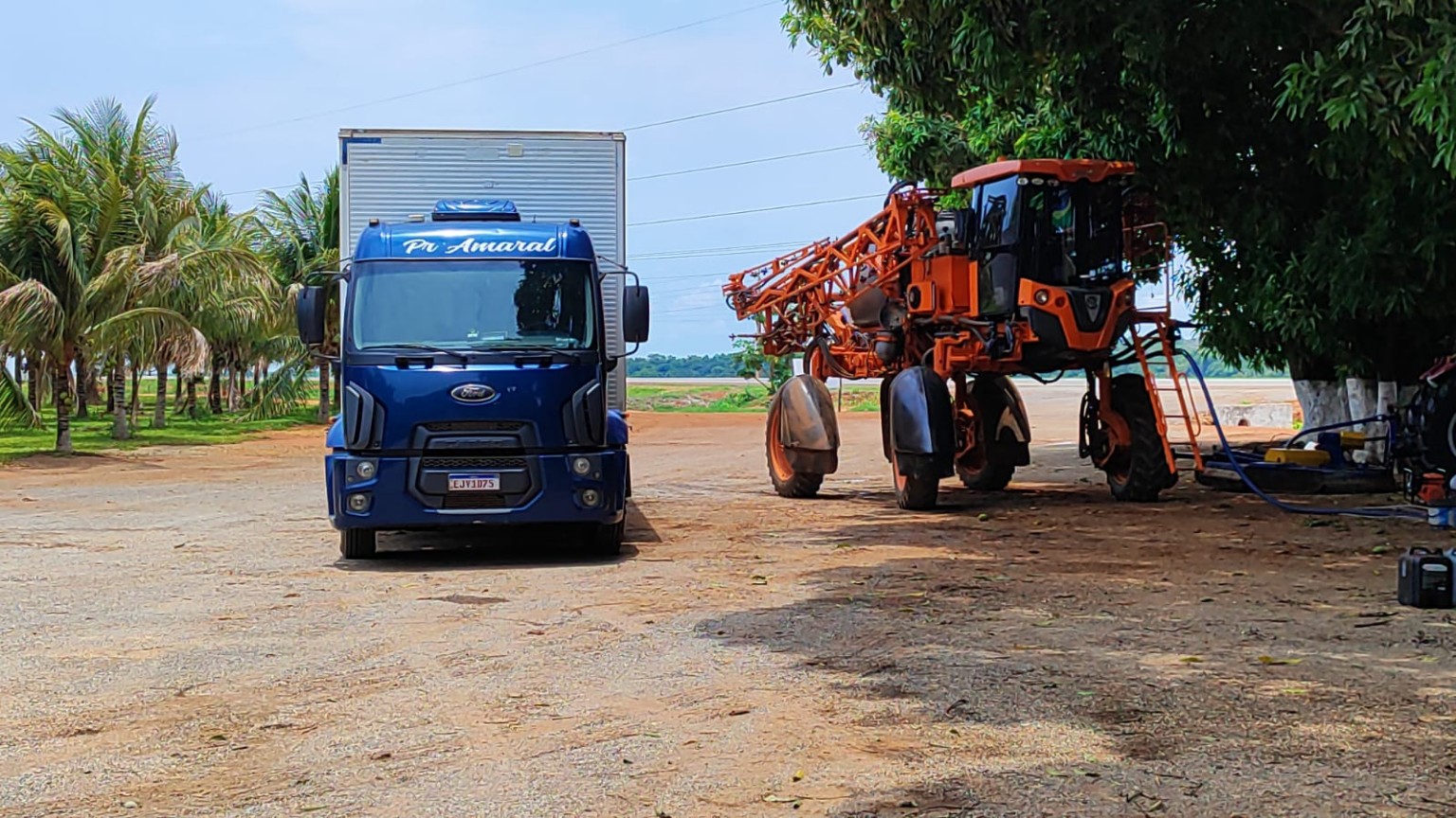 Caminhão da PR Amaral ao lado de máquina agrícola